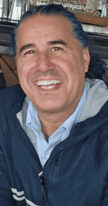 Our CEO and Founder picture in a blue jacket smiling.
