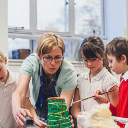 Students and a teacher creating a volcano