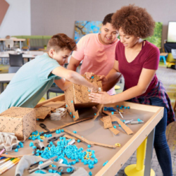 A picture of teacher and students doing a project.